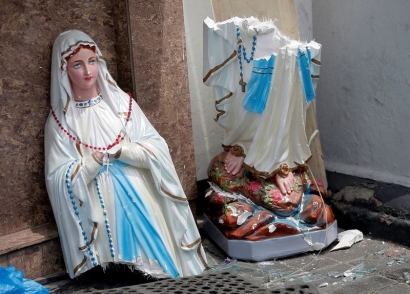 Berdoa di Depan Patung Maria yang Tak Sempurna