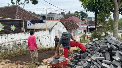 Ikut Kerja Bakti, Mahasiswa KKN-T UNIRA Malang Membantu Masyarakat Pemasangan Paving