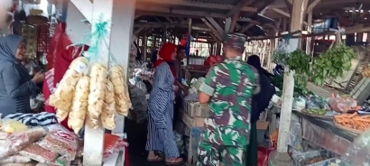 Babinsa Desa Bojongasih Serda Andrianis Bagikan Masker di Pasar