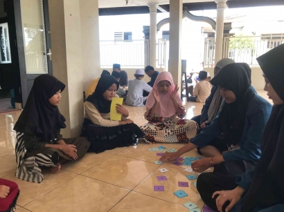 Memupuk Melek Literasi dan Menabung di Era Media Sosial yang Masif Kepada Anak-anak TPQ Al Ikhlas Bersama Mahasiswa KKN - BBK 3 Unair
